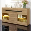 A modern wooden sideboard with illuminated shelves, decorated with framed pictures and decorative cactus figures. Produktbild-Vorschau