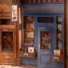 A miniature bookstore facade with shelves filled with books and signage. Podgląd zdjęcia produktu