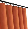 A close-up view of several orange curtains hanging from a black curtain rod. Podgląd zdjęcia produktu