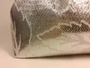 A close-up view of the corner of a silver fabric item with a patterned texture. Podgląd zdjęcia produktu