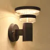 A modern black LED wall light with a clear glass shade is mounted on a light-colored wall. Produktbild-Vorschau