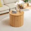 A round bamboo coffee table with a book and a vase of dried flowers on top, placed on a light-colored rug next to a sectional sofa. Náhľad obrázku produktu