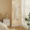A bedroom scene with a nightstand, bed, and a white coat rack. Náhľad obrázku produktu