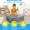 A young boy is playing with building blocks on a folded gray mattress in a children's room. There are shelves with toys and a decorative basket in the background. Three circular icons with text are at the bottom of the image, highlighting product features. Podgląd zdjęcia produktu