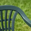 A close-up of a green garden chair with a blurred green lawn in the background. Náhled obrázku produktu