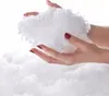Hands holding a pile of white fluffy material, likely stuffing or batting, against a white background. Anteprima dell’immagine prodotto