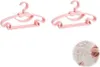 Two pink hangers shaped like cars are shown against a white background. A close-up inset shows a hand holding one of the hangers near a baby outfit. Produktbild-Vorschau
