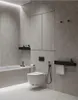 A modern, minimalist bathroom with gray tiled walls and floor, featuring a bathtub, toilet, and bidet sprayer. Podgląd zdjęcia produktu