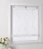 A white window with a sheer roller blind with a wavy embroidered pattern and small beads. Produktbild-Vorschau