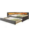 A grey upholstered daybed with a pull-out trundle bed, illuminated by orange LED lights. Voir les images du produit