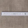 A close-up of a folding ruler on a textured fabric background. Produktbild-Vorschau