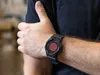 A person wearing a black t-shirt and a black digital watch with a red display. Produktbild-Vorschau