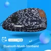 A close-up of a black and white patterned headband with integrated Bluetooth headphones, set against a blue background with abstract spheres. Produktbild-Vorschau