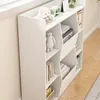 A white bookshelf with various items on its shelves, placed near a window. Náhľad obrázku produktu
