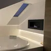 A modern bathroom with a large bathtub and a wall-mounted bioethanol fireplace. Náhled obrázku produktu