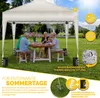 A family is enjoying a meal under a beige pop-up gazebo in a garden. Anteprima dell’immagine prodotto