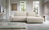 A modern living room with a cream-colored sectional sofa, a rug, and artwork on the wall. Produktbild-Vorschau