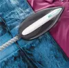 A steam iron placed on a pair of blue jeans and a pink shirt. Voir les images du produit