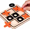 A hand is placing an orange 'X' piece onto a wooden tic-tac-toe board. Náhled obrázku produktu