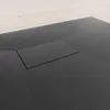 A close-up view of a black shower tray with a rectangular drain cover. Produktbild-Vorschau