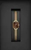 A gold-colored watch with a brown face is presented in a black box. Voir les images du produit