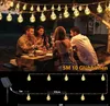 People enjoying an outdoor dinner party illuminated by string lights. Podgląd zdjęcia produktu