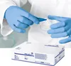 A person wearing blue nitrile gloves is shown performing a task with laboratory equipment, with a box of the gloves in the foreground. Anteprima dell’immagine prodotto