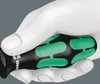 A close-up of a white, stylized hand holding a black screwdriver with green accents. Produktbild-Vorschau