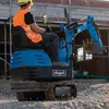 A construction worker operating a mini excavator on a gravel surface. Produktbild-Vorschau