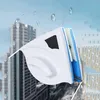 Weiß-blauer magnetischer Fensterreiniger an einem Fenster mit Wassertropfen, im verschwommenen Hintergrund Stadtgebäude Náhľad obrázku produktu