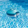 A blue and white pool chemical dispenser floating on the surface of a swimming pool. Produktbild-Vorschau