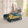 A folded blanket with a floral pattern is placed on a bed. Produktbild-Vorschau