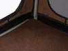 Close-up view of the corner of a brown dog crate, showing the carpeted floor and metal frame. Produktbild-Vorschau