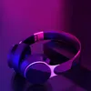 A pair of headphones is displayed on a dark surface with purple and blue lighting. Produktbild-Vorschau