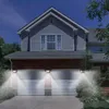 Two solar-powered LED lights illuminate the front of a house with a double garage at dusk. Produktbild-Vorschau