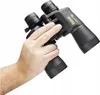 A hand holding a pair of black Bushnell binoculars. Produktbild-Vorschau