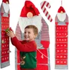 A young boy is interacting with a large, hanging Christmas advent calendar shaped like a gnome. Produktbild-Vorschau