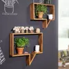 Two wooden shelves in a speech bubble shape mounted on a dark gray wall, decorated with plants and jars. Produktbild-Vorschau