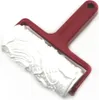 A white embossed roller with a red handle, shown at a slight angle against a white background. Produktbild-Vorschau