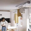 A woman is listening to music and dancing in a room with a ceiling-mounted clothes drying rack. Podgląd zdjęcia produktu