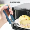 A hand is using a pair of tongs to remove a plate with food from an oven. Produktbild-Vorschau