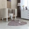 A baby is climbing out of a crib in a nursery room. Produktbild-Vorschau
