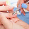 A close-up shot of a person's hands performing a manicure, using a cuticle pusher tool on a fingernail. Náhled obrázku produktu