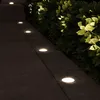 A pathway illuminated by ground lights next to a hedge at night. Produktbild-Vorschau