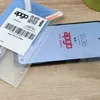 A screen protector package and a smartphone with a screen protector applied. Produktbild-Vorschau