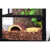 A close-up view of a terrarium with bark, a hide, and substrate. Anteprima dell’immagine prodotto