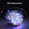A string of colorful LED lights submerged in a glass bowl of water, with white stones at the bottom. Produktbild-Vorschau