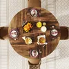 A top-down view of a round wooden dining table set for a meal, with chairs around it. Podgląd zdjęcia produktu