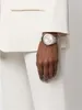 A person wearing a white suit and a silver watch. Produktbild-Vorschau