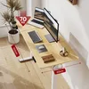 A modern standing desk with dual monitors and a laptop, set up in a home office environment. Voir les images du produit